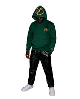 Person wearing a green streetwear hoodie with a logo and black pants on a white background
