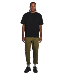 Person wearing a black core t-shirt and green pants on a white background