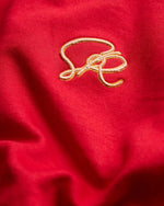 Close-up of a red fabric with gold embroidery on the red sweatshirt
