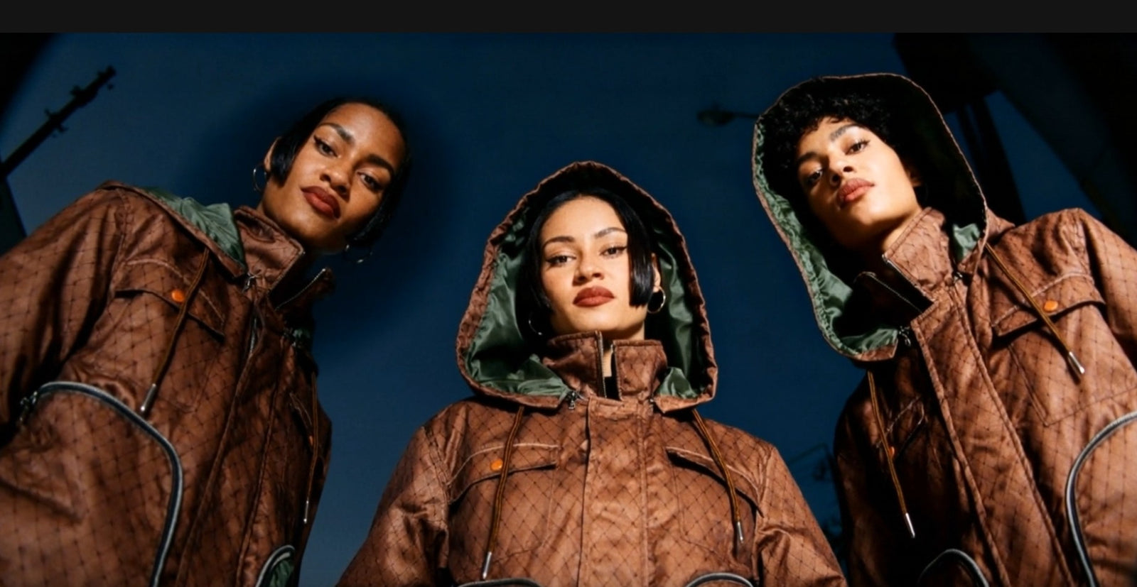 Three individuals wearing Versa Workwear Jackets against a dark blue background