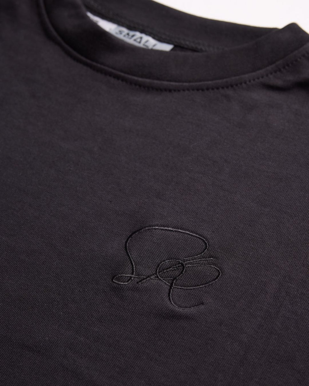 Black crew neck  with a small embroidered logo on a plain background