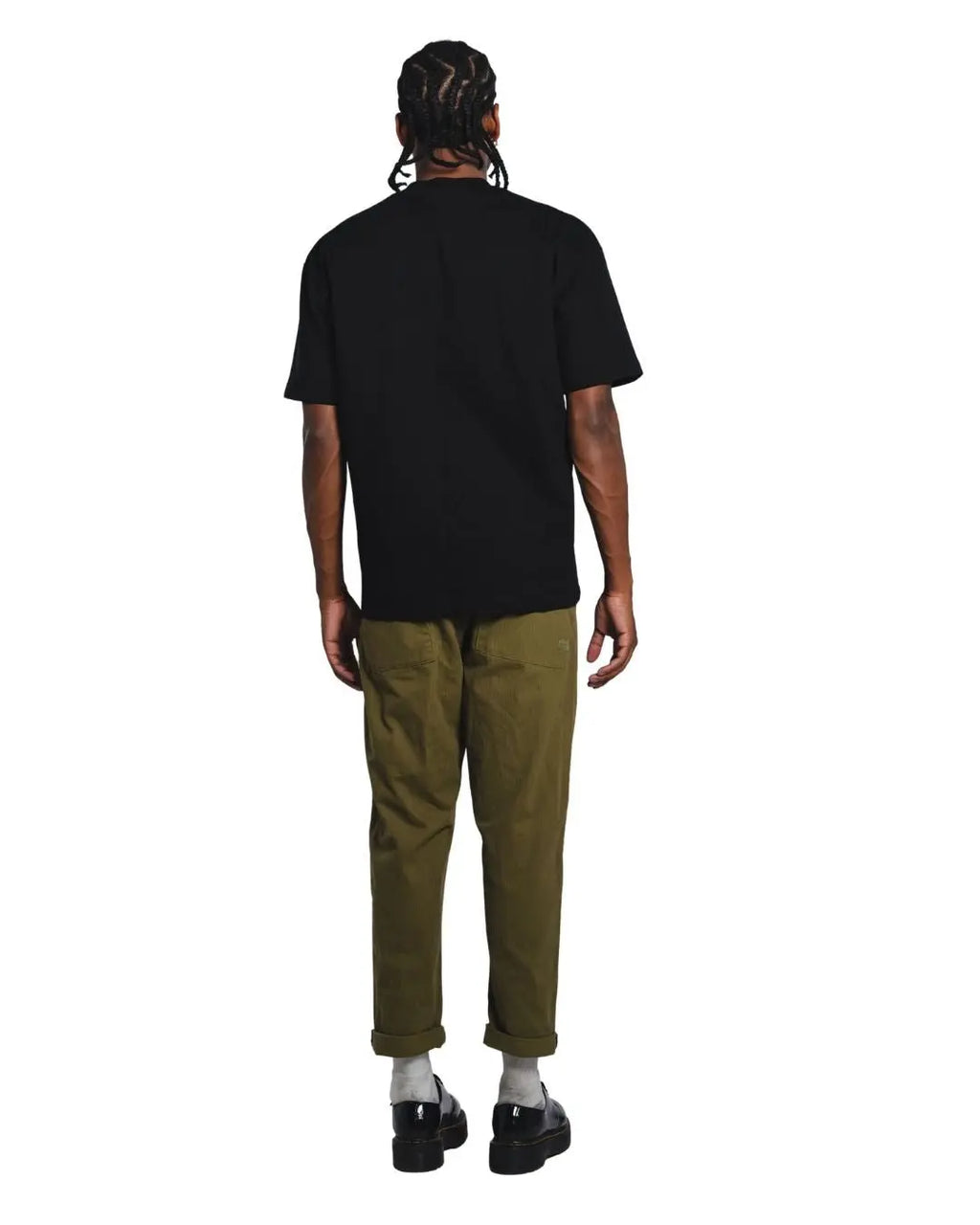 Person wearing a black t-shirt and green pants on a white background facing backward